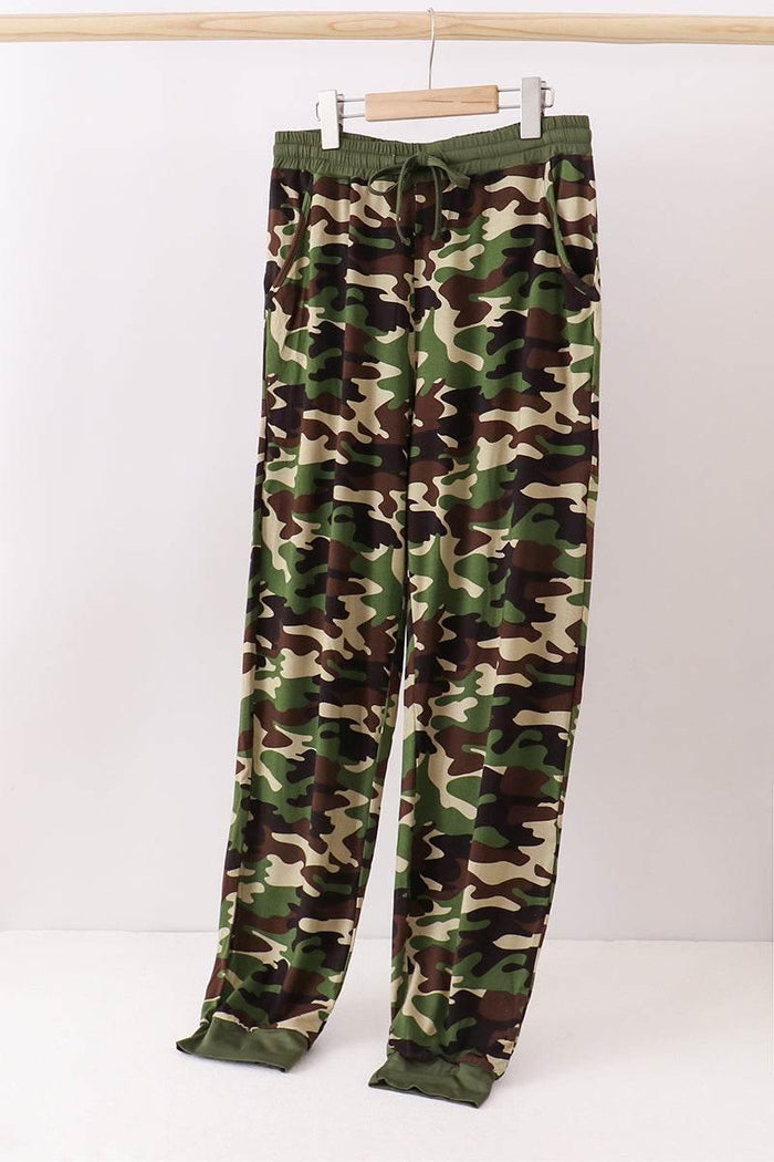 Camouflage pants on a hanger against a white background